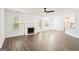 Spacious living room with a fireplace, ceiling fan, and wood flooring, enhanced by natural light from surrounding windows at 2580 Star Ln, Decatur, GA 30034