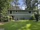 Home exterior featuring siding, windows, a backyard, and surrounded by trees at 6875 Timberclair Ct, Lithonia, GA 30058