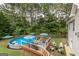 Aerial view of a backyard with an above-ground pool, a deck, patio seating and a grassy area at 53 Denny Ln, Dallas, GA 30157