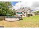 Backyard with above-ground pool, patio seating, a grassy area and a two-story house in the background at 53 Denny Ln, Dallas, GA 30157