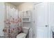 Cozy bathroom showcasing a toilet, storage cabinet and a floral-patterned shower curtain at 53 Denny Ln, Dallas, GA 30157