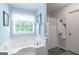 Bright bathroom featuring a large soaking tub next to a large window, a shower and tiled floors at 53 Denny Ln, Dallas, GA 30157