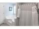 Bright bathroom featuring a large soaking tub, and a shower with decorative white towels and curtain at 53 Denny Ln, Dallas, GA 30157