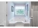 Bright bathroom featuring a large soaking tub, and a shower with decorative white towels and curtain at 53 Denny Ln, Dallas, GA 30157