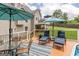 Relaxing deck with lounge chairs, table, and umbrella next to pool, overlooking a grassy lawn at 53 Denny Ln, Dallas, GA 30157