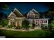 Nighttime view of a beautiful home with stone and siding, enhanced by landscape lighting and a starry sky at 53 Denny Ln, Dallas, GA 30157