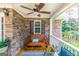 Inviting front porch with a wooden swing, patterned rug, and decorative plants for a cozy outdoor space at 53 Denny Ln, Dallas, GA 30157