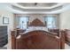 Inviting primary bedroom featuring a decorative tray ceiling, ceiling fan, and a large decorative wood headboard at 53 Denny Ln, Dallas, GA 30157