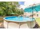 Backyard featuring an above ground pool with blue water, surrounded by lush greenery and patio furniture at 53 Denny Ln, Dallas, GA 30157