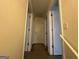 Hallway with multiple doors, a partial railing, and access to other areas of the home at 110 Riley Ave, Fayetteville, GA 30214