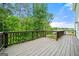 An empty wooden deck surrounded by a dense forest and blue sky at 3865 Rifflepool Ct, Douglasville, GA 30135