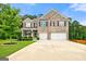Charming two-story brick home with a well-manicured lawn and a spacious three-car garage at 3865 Rifflepool Ct, Douglasville, GA 30135