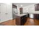 Kitchen with stainless steel refrigerator, dark cabinets, granite countertops, kitchen island and an open floor plan at 3865 Rifflepool Ct, Douglasville, GA 30135