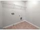Efficient laundry room with overhead wire shelving and tile flooring at 3865 Rifflepool Ct, Douglasville, GA 30135