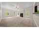 Spacious living room with white trim and walls, light carpet, fireplace, and large windows at 3865 Rifflepool Ct, Douglasville, GA 30135