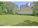 Large backyard featuring a lush green lawn, mature landscaping, and a private fence at 1709 Reese Rd, Sharpsburg, GA 30277