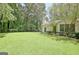 Backyard with lush green lawn, privacy fence and mature trees, great for outdoor enjoyment at 1709 Reese Rd, Sharpsburg, GA 30277