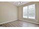 Bedroom with hardwood floors, one large window with blinds and neutral walls at 1709 Reese Rd, Sharpsburg, GA 30277