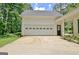 A two-car garage featuring a white paneled door, adjacent to a covered carport, offering parking and storage at 1709 Reese Rd, Sharpsburg, GA 30277