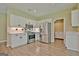 Well-lit kitchen features stainless steel appliances, white cabinets, and a complementing backsplash at 1709 Reese Rd, Sharpsburg, GA 30277