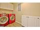Functional laundry room features matching red washer and dryer sets and white storage cabinets at 1709 Reese Rd, Sharpsburg, GA 30277