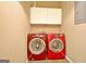 Bright laundry area with overhead cabinets and matching red washer and dryer sets at 1709 Reese Rd, Sharpsburg, GA 30277