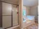 Bright bathroom featuring a glass shower and a separate soaking tub with tile surround at 1875 Tree Brooke Ln, Snellville, GA 30078