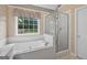 Bright bathroom with a garden tub, glass shower, and a window to the backyard at 65 Pecan Ln, Oxford, GA 30054