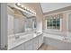 Bathroom with double sinks, a bathtub, a shower, and a window to provide natural light at 65 Pecan Ln, Oxford, GA 30054