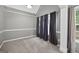 This bedroom has carpet flooring and a window with curtains providing natural light at 65 Pecan Ln, Oxford, GA 30054