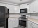 Bright kitchen with white cabinetry, stainless steel appliances, and ample counter space for meal preparation and gatherings at 65 Pecan Ln, Oxford, GA 30054