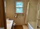 Bathroom with patterned wallpaper, vanity, toilet, shower-tub combo, and a window at 807 Oak Bridge Ln, Fayetteville, GA 30214