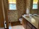 Full bathroom featuring vanity with drawers and wallpapered accent wall at 807 Oak Bridge Ln, Fayetteville, GA 30214