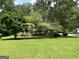 Inviting home with a covered front porch surrounded by mature trees and lush lawn at 807 Oak Bridge Ln, Fayetteville, GA 30214