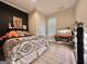 Bedroom with dark accent wall, patterned bedspread, and wooden floors at 6192 Collins Ne St, Covington, GA 30014