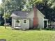 Quaint house featuring a small covered porch, a red brick chimney and a side yard at 6192 Collins Ne St, Covington, GA 30014