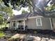 Quaint home with a covered porch, gray siding, stone pathway and manicured garden at 6192 Collins Ne St, Covington, GA 30014