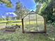 Exterior view of a backyard greenhouse with raised garden beds ready for planting at 6192 Collins Ne St, Covington, GA 30014
