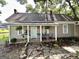 Inviting front porch with chairs, plants, and a light green door, and stone walkway at 6192 Collins Ne St, Covington, GA 30014