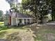 Charming single-story home featuring a cozy front porch, green lawn, and mature trees at 6192 Collins Ne St, Covington, GA 30014