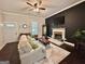 Cozy living room with a fireplace, dark wood flooring, neutral walls and a ceiling fan at 6192 Collins Ne St, Covington, GA 30014