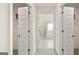 Bright hallway featuring open closet and bathroom doors leading to a well-lit modern bathroom at 687 Edgar St # 83, Hampton, GA 30228