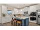 Modern kitchen with white cabinetry, stainless steel appliances, a blue island, and stylish seating provides great space at 687 Edgar St # 83, Hampton, GA 30228