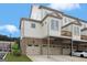 Exterior of a new townhome, featuring a ground level garage, and tan and white siding at 1100 Thomas St, Woodstock, GA 30188