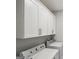 Bright laundry room featuring modern white cabinets, washer, and dryer at 1100 Thomas St, Woodstock, GA 30188