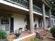Spacious front porch featuring brick flooring, stately columns, decor, and well manicured landscape at 5523 Bahia Mar Cir, Stone Mountain, GA 30087