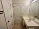 Well-lit bathroom featuring white fixtures, a mirror, and neutral-toned tile flooring at 6367 Ellenwood Drive, Rex, GA 30273