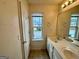 Well-lit bathroom with dual sinks, a large mirror, and a view from the window at 6367 Ellenwood Drive, Rex, GA 30273