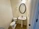 A cozy half-bath features vinyl flooring, a white pedestal sink, and toilet at 6367 Ellenwood Drive, Rex, GA 30273