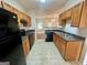 Kitchen area with oak cabinets, black appliances, and tile flooring at 6367 Ellenwood Drive, Rex, GA 30273